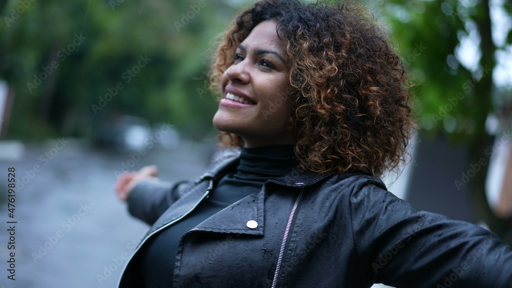 Young black woman standing in the rain looking at sky with HOPE and ...