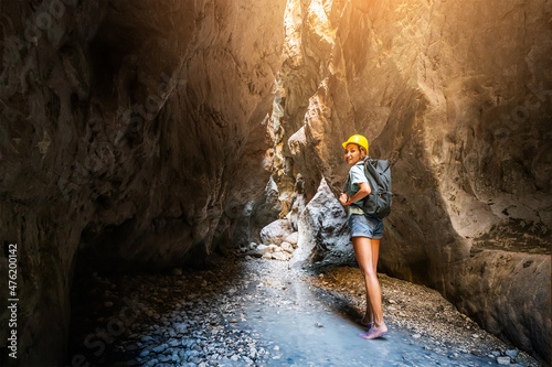 Happy alone woman wearing helmet for safety is engaged in active canyoning and hiking along the Saklikent Gorge in Turkey. New experience and outdoor leisure recreation photo