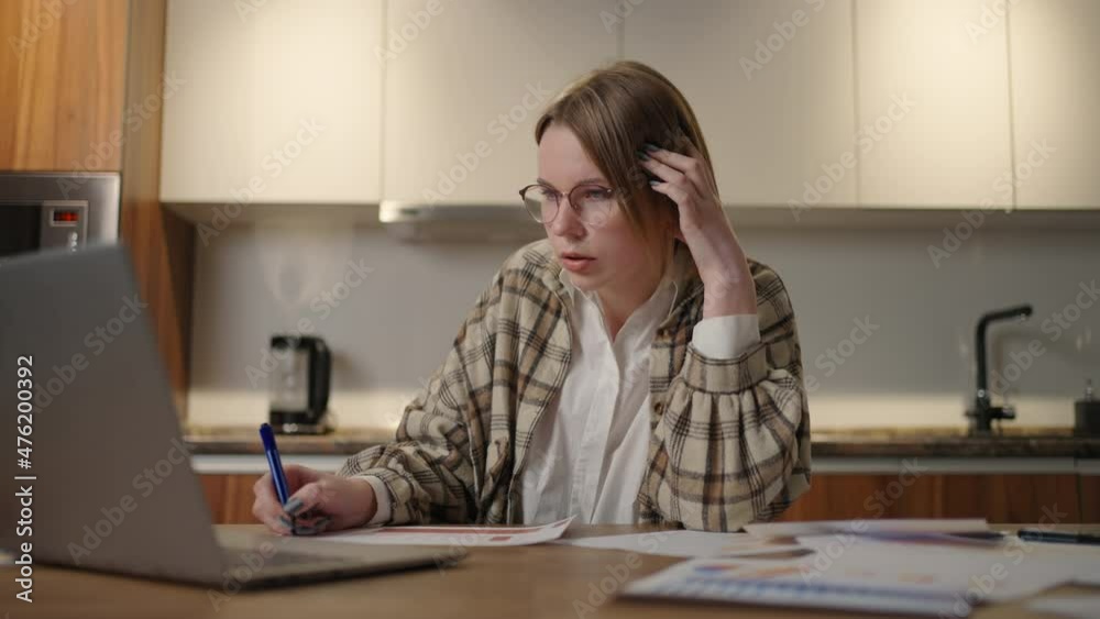 A woman with glasses Distance learning student at home to perform an assignment in economics A woman with glasses Distance learning student at home to perform an assignment in economics
