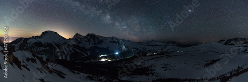 Wonderful starry sky milky way and majestic mountain range in Sunshine Village. Ski village at night. Winter landscape with village in mountains, Banff, Canada
