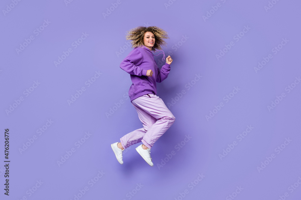 Photo of charming sweet woman wear sweatshirt jumping high running fast isolated violet color background