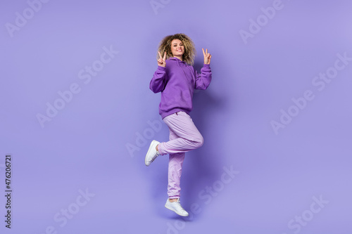 Photo of adorable pretty lady dressed hoodie humping high showing v-signs isolated purple color background