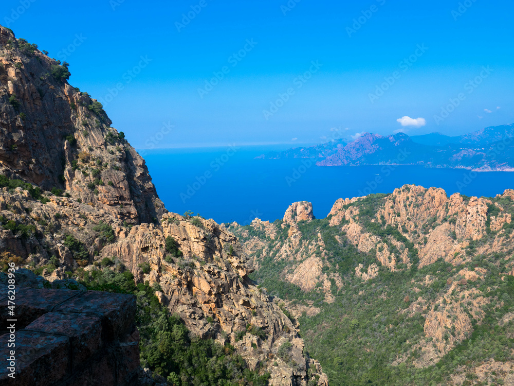 Aerial view of beautiful view of sunlit red mountains and the Mediterranean Sea with the Bay of Porto in Calanches area near Piana. Corsica island. Tourism and vacaions concept.