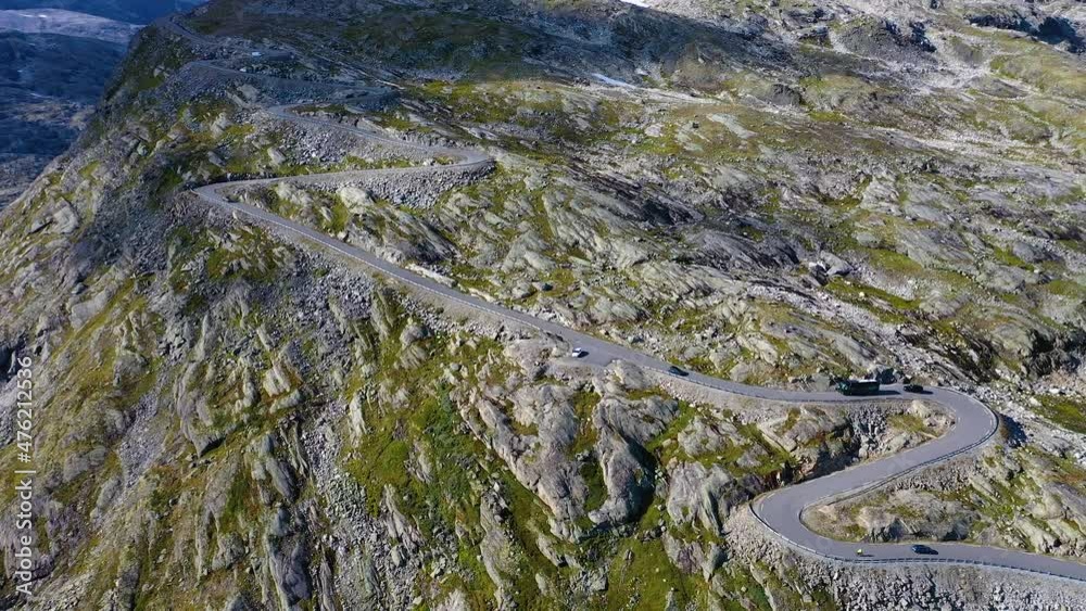 Vehicles driving up on a dangerous and curvy mountain pass road, Aerial view Vehicles driving up on a dangerous and curvy mountain pass road, Aerial view