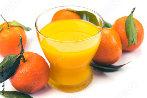 fresh orange juice and clementines with leaves isolated on white background