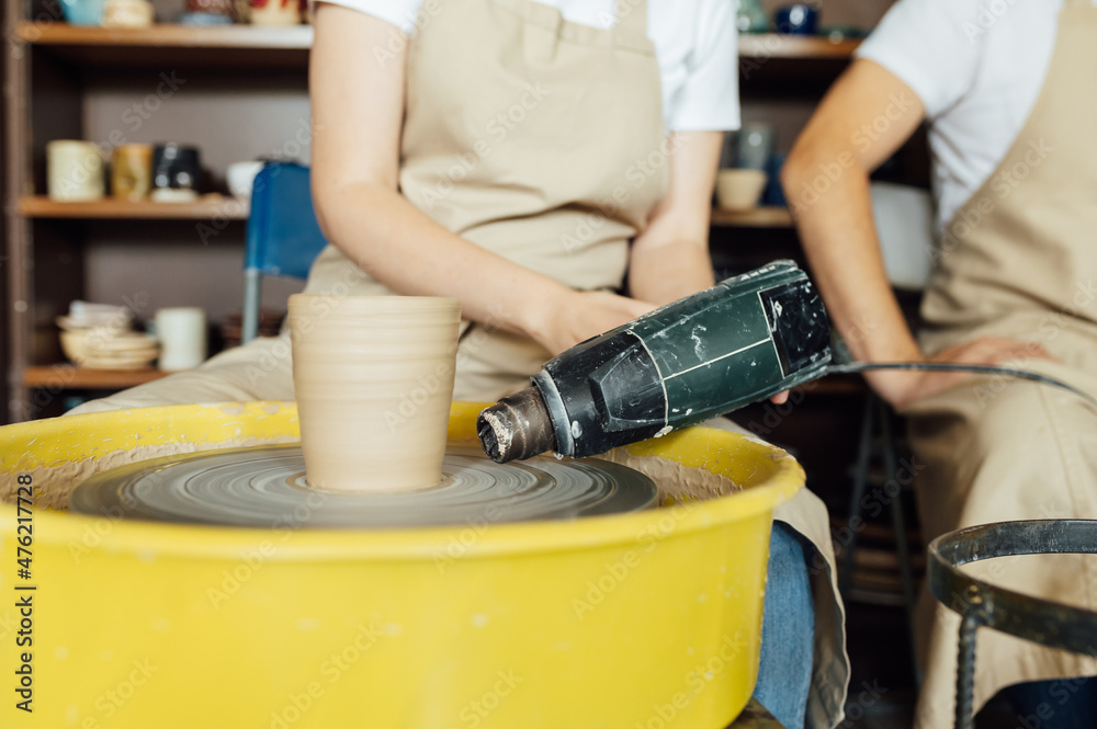 Hands of a potter. Potter making ceramic pot on the pottery wheel Hands of a potter. Potter making ceramic pot on the pottery wheel