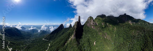 Vibrant wide aerial panorama landscape of mountain range Serra dos Orgaos in Teresopolis, Rio de Janeiro in Brazil with clouds over the rocky peaks. Natural reserve and mountainous Atlantic forest photo
