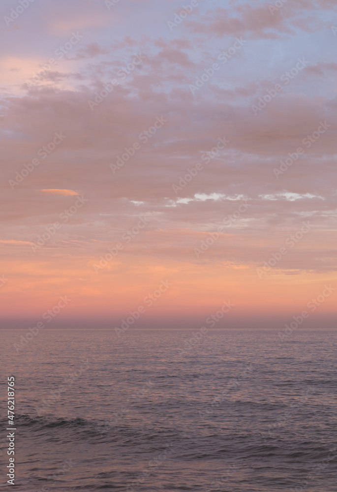 Fototapeta premium Orange, pink and lilac sunset sky in the sea. 