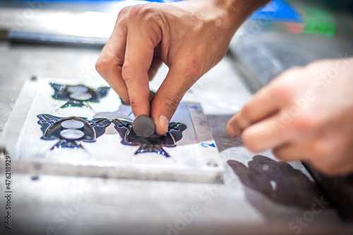Technician making fridge magnet with soft PVC rubber in mold