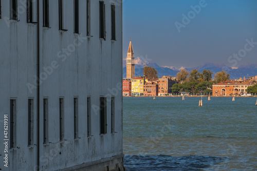 un edificio grigio accanto a una parte colorata di venezia photo