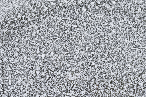 The texture of rime crystals on a frozen surface. Winter background.