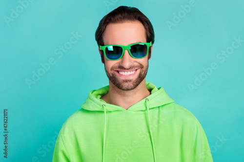 Photo of confident cheerful handsome guy summer vacation wear sunglass green hoodie isolated teal color background