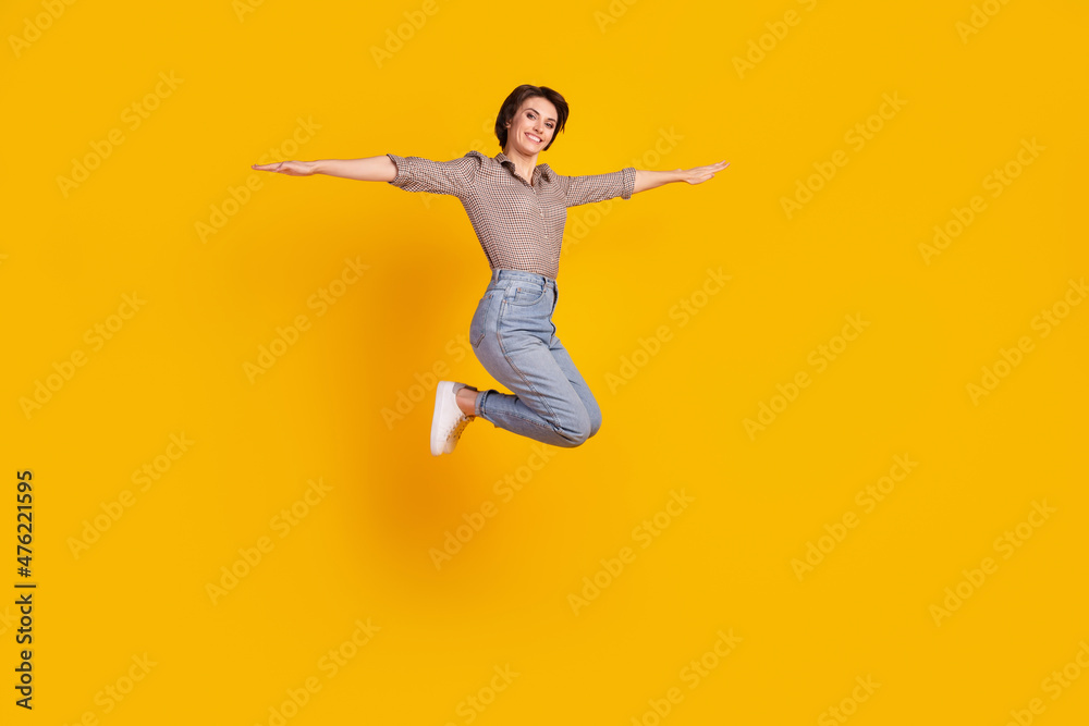 Full size profile side photo of young pretty woman jump up fly hands plane isolated over yellow color background