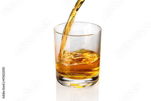 Whisky, whiskey or bourbon pouring into whisky glass isolated on white, copy space