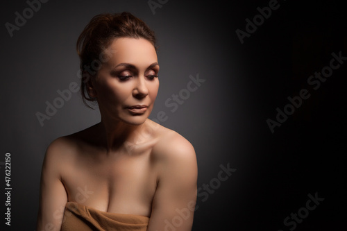 portrait of a sensual fifty year old woman on grey studio background