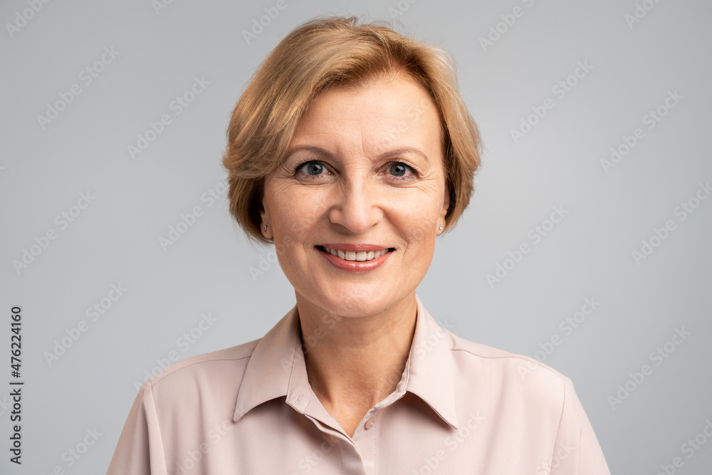 Cheerful woman in casual style clothes looking at camera with toothy smile, expressing happiness and joy, positive emotions. Indoor studio shot isolated on grey background Cheerful woman in casual style clothes looking at camera with toothy smile, expressing happiness and joy, positive emotions. Indoor studio shot isolated on grey background