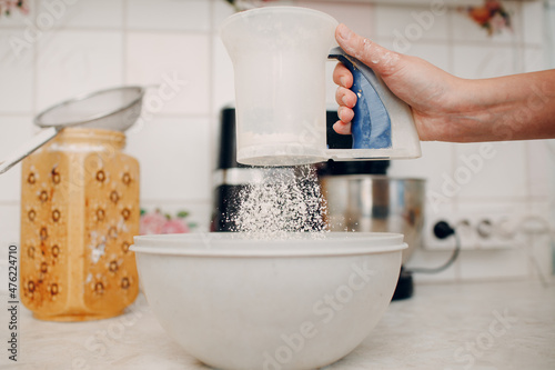 Pastry chef sift pours flour makes cake. Cooking and preparing dessert.