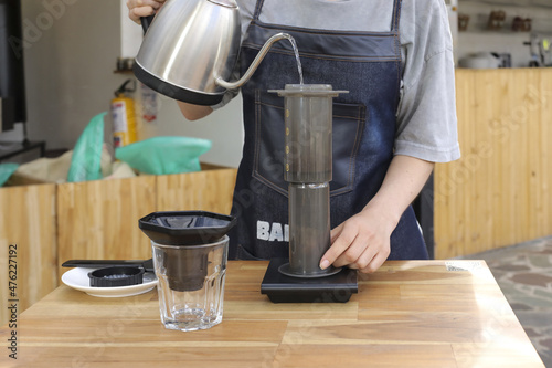 Billede på lærred Barista pouring water in a manual coffeemaker on a food weight scale
