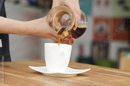 Fotografia Barista pouring coffee from a manual pour-over coffeemaker into a cup