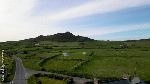 Welsh village and Carn Llidi hill in background. Aerial rising photo