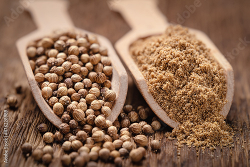 Close-up shot of coriander seeds in wood scoop whole and ground photo