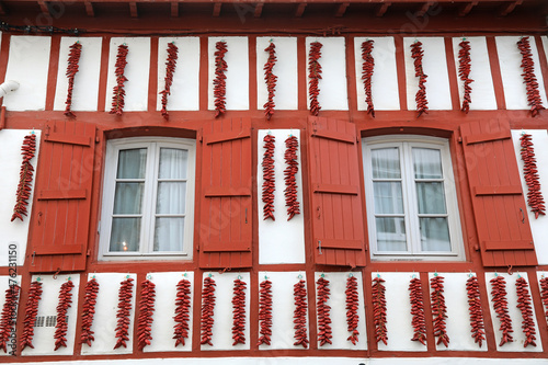 espelette pimientos rojos colgados el la fachada de una casa con ventanas rojas francia país vasco francés 4M0A8003-as21