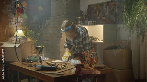 Wallpaper Mural Mature woman carpenter sand wood board in a small workshop Torontodigital.ca