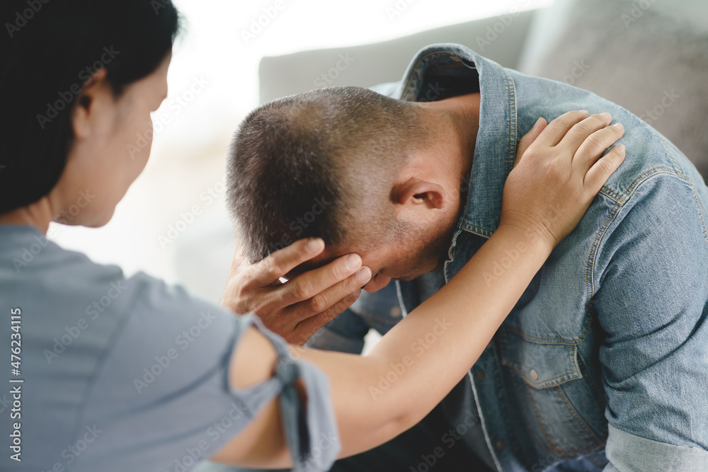 Female Psychologist, friend or family sitting and put hands on the shoulder for cheer up to mental depress man, Psychologist provides mental aid to the patient. PTSD Mental health concept.