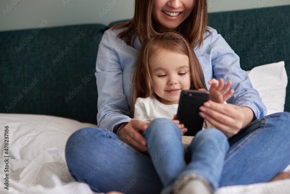 Mother and daughter using smartphone together
