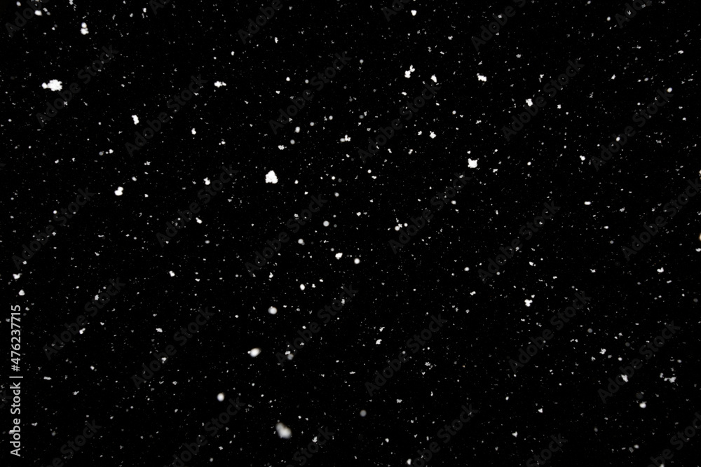 Falling snow freeze motion in the dark sky. Texture isolated on black background. Perfect for white snowflakes overlay, winter mood