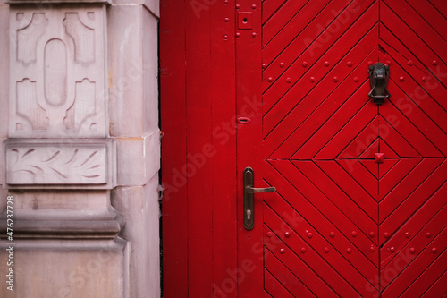 closed wooden red door in a beautiful old house in the city center close-up. Door lock in wooden door exterior of vintage house © Irina