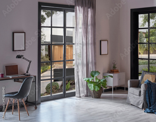 Modern rom with working table and armchair style, parquet floor, frame lamp decor, curtain, garden view house interior.