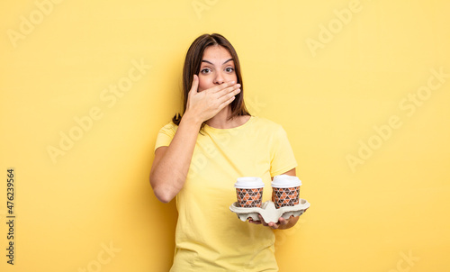 pretty woman covering mouth with hands with a shocked. take away coffee concept photo