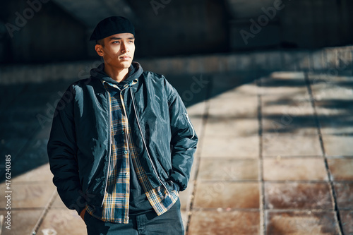 Portrait of young hipster man posing on urban street background