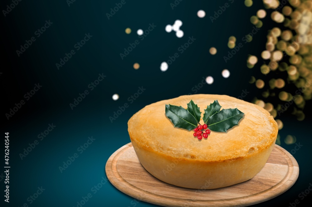 Christmas pudding, fruit cake. Traditional festive dessert. Dark background with lights garland. Christmas pudding, fruit cake. Traditional festive dessert. Dark background with lights garland.