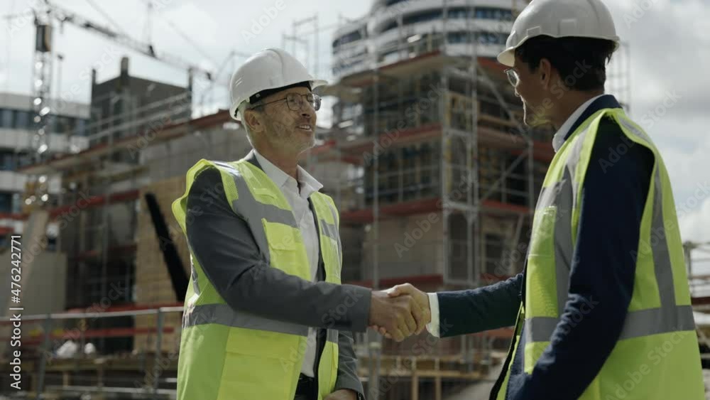 Two men standing on construction site and shaking hands