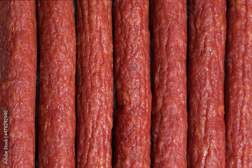 Smoked sausage thin top view. Hunting sausages close up background. Lots of smoked sausage. Meat to beer snacks.