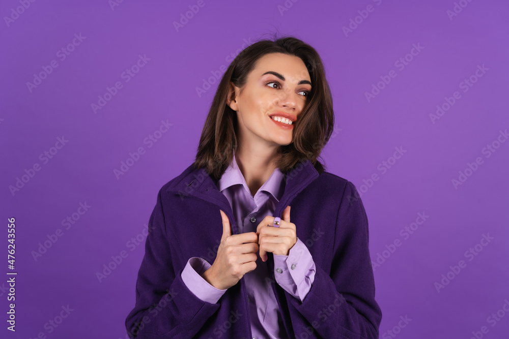 Young woman in a woolen coat on a purple background posing, cozy and warm, autumn-winter style, smiling confidently with lipstick on her lips Young woman in a woolen coat on a purple background posing, cozy and warm, autumn-winter style, smiling confidently with lipstick on her lips