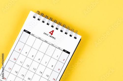 April 2022 desk calendar on yellow background.