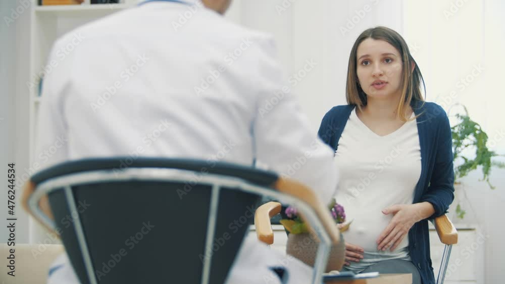 4k video of pregnant woman speaking with a doctor. 4k video of pregnant woman speaking with a doctor.