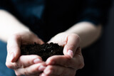 woman hands holding dark moist soil. Agriculture, organic gardening, planting or ecology concept. Environmental, earth day. Banner. Copy space