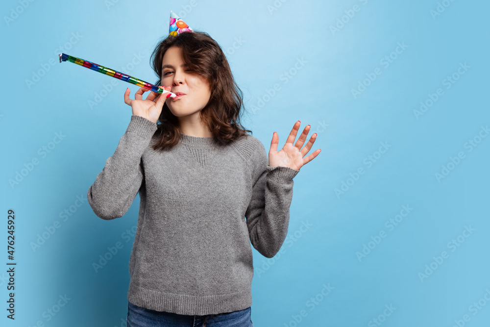 Half-length portrait of smiling young beautiful girl in warm knitted sweater isolated on blue color background Half-length portrait of smiling young beautiful girl in warm knitted sweater isolated on blue color background