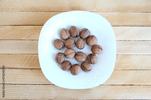Walnuts in the plate on a wooden background