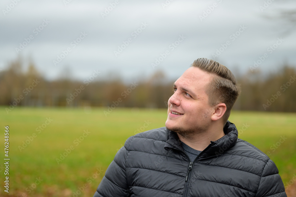 Young man smiling in fascination as he looks to the side Young man smiling in fascination as he looks to the side