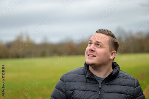 Fotografija Young man smiling in fascination as he looks to the side