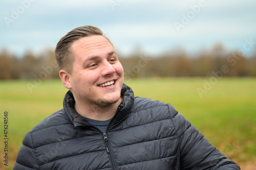 Cheerful upbeat young man looking aside with a smile