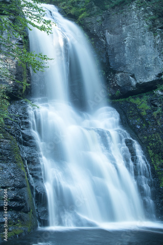 Beautiful waterfall shot with long shutter for smooth water falling over a large cliff of rock in the forest