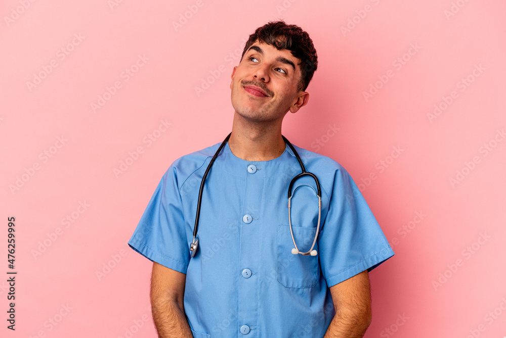 Young mixed race nurse man isolated on pink background dreaming of achieving goals and purposes Young mixed race nurse man isolated on pink background dreaming of achieving goals and purposes