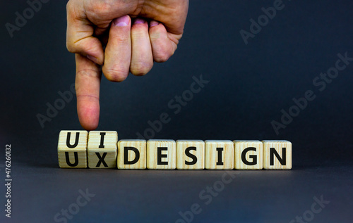 UX user experience design or UI user interface design symbol. Businessman turns cubes, changes words UX design to UI design. Beautiful grey background. Business UX or UI design concept. Copy space.