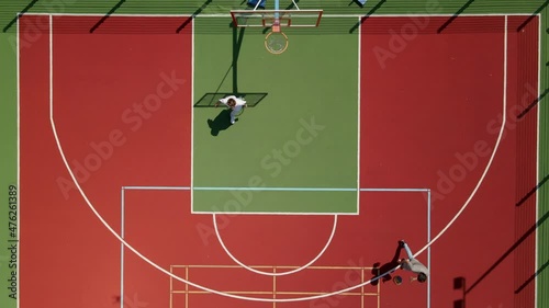 Aerial yop down view of two young male friends playing basketball on court outdoors photo